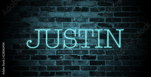first name Justin in blue neon on brick wall photo