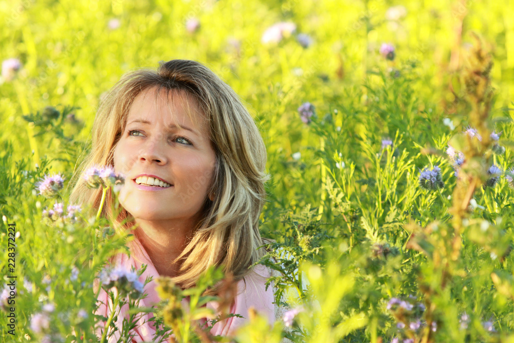 Happy mature woman enjoys leisure time in a flowerfield Happy mature woman enjoys leisure time in a flowerfield
