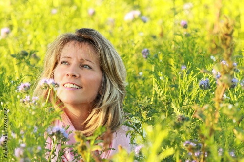 Happy mature woman enjoys leisure time in a flowerfield