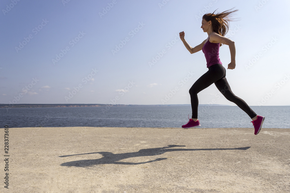 Young beautiful girl jogging and training on the beach Young beautiful girl jogging and training on the beach