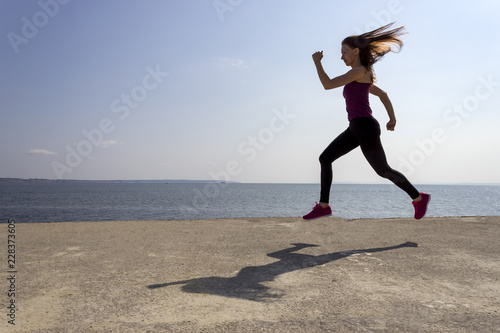 Fototapeta Naklejka Na Ścianę i Meble -  Young fit girl running and training on the beach