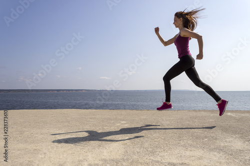 Fototapeta Naklejka Na Ścianę i Meble -  Young beautiful girl jogging and training on the beach
