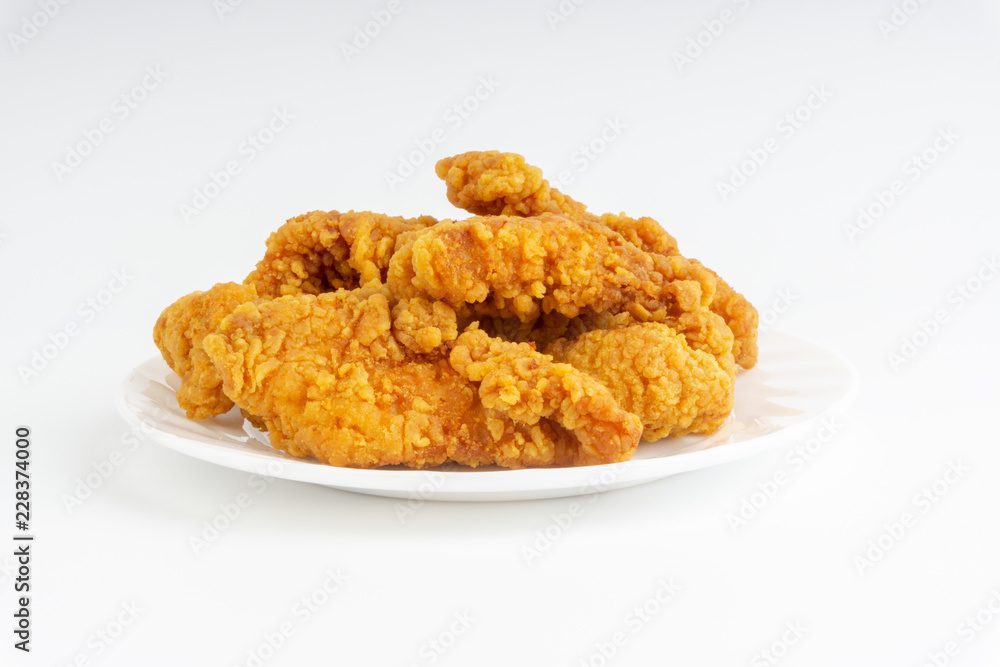 Fried breaded chicken fillet isolated on white background with selective focus and crop fragment Fried breaded chicken fillet isolated on white background with selective focus and crop fragment