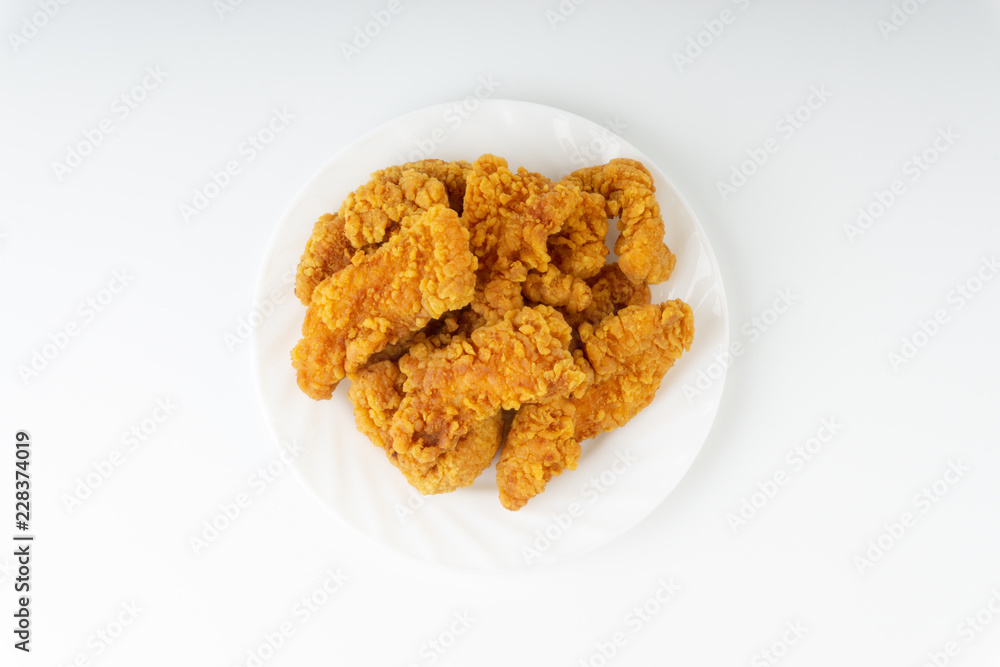 Fried breaded chicken fillet isolated on white background with selective focus and crop fragment Fried breaded chicken fillet isolated on white background with selective focus and crop fragment