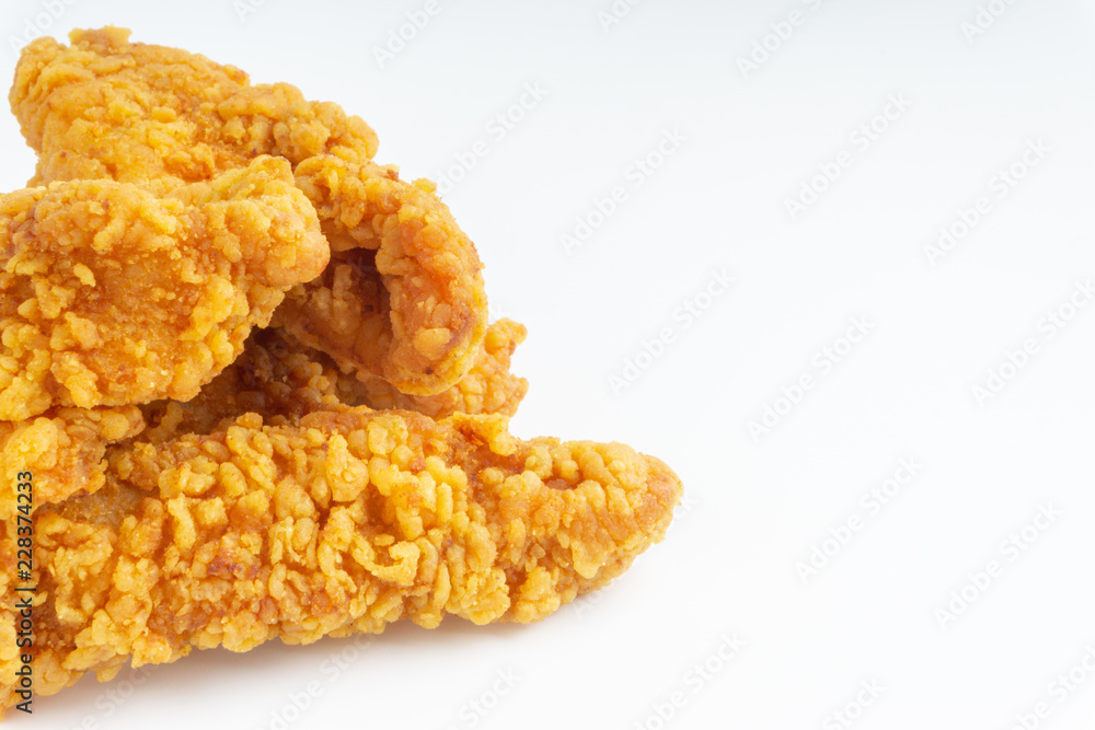 Fried breaded chicken fillet isolated on white background with selective focus and crop fragment Fried breaded chicken fillet isolated on white background with selective focus and crop fragment