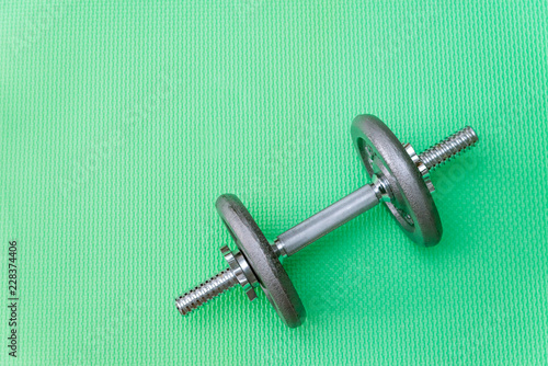 gray dumbbell with disks on a green background