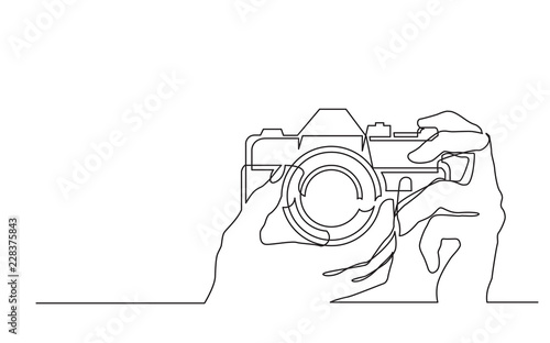 continuous line drawing of hand holding photo camera making pictures