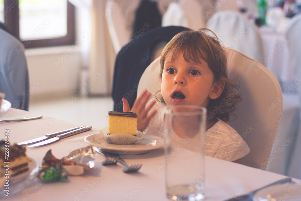 The little girl eats at the restaurant with cutlery The little girl eats at the restaurant with cutlery