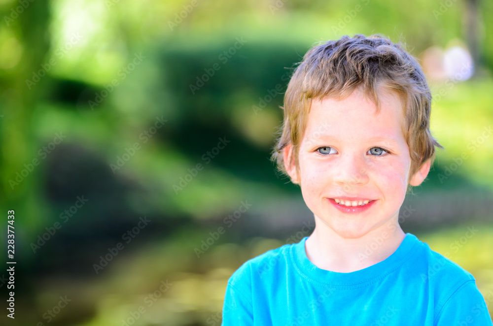 Portrait of a small five year old caucasian boy in the park Portrait of a small five year old caucasian boy in the park