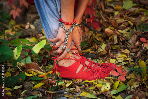 closeup of woman legs and hands in yoga stretch pose in colorful autumn leaves outdoor