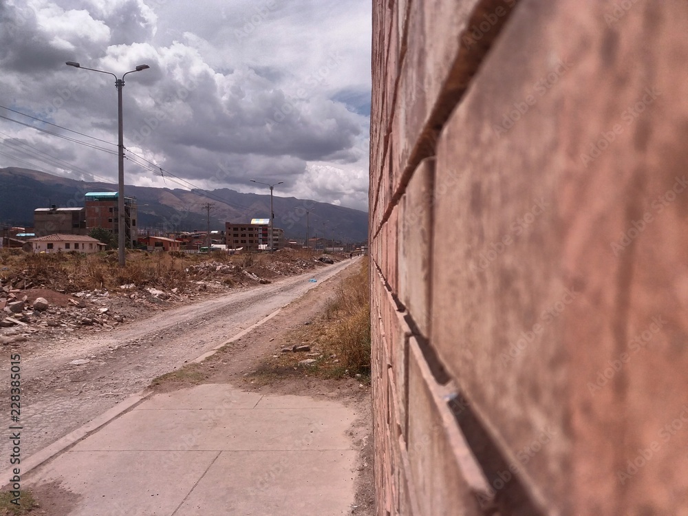  nearby bricks, dirt track to side, cloudy sky background, location cusco, peru.