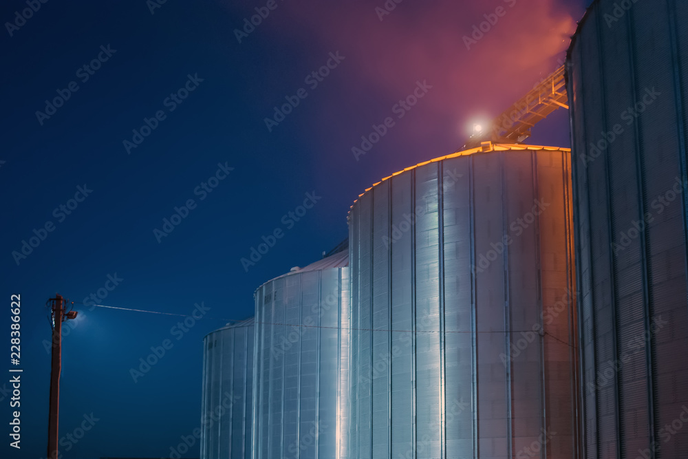 Elevator at night sometimes performs work on receiving, cleaning, drying and storing grain - obrazy, fototapety, plakaty 
