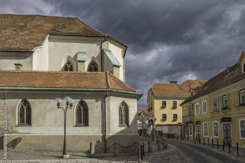 Street in old town Celje with parish church, Slovenia