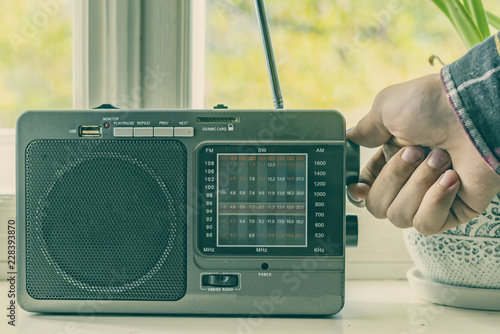 hand adjusting the settings of vintage old radio, search for radio station wave f photo