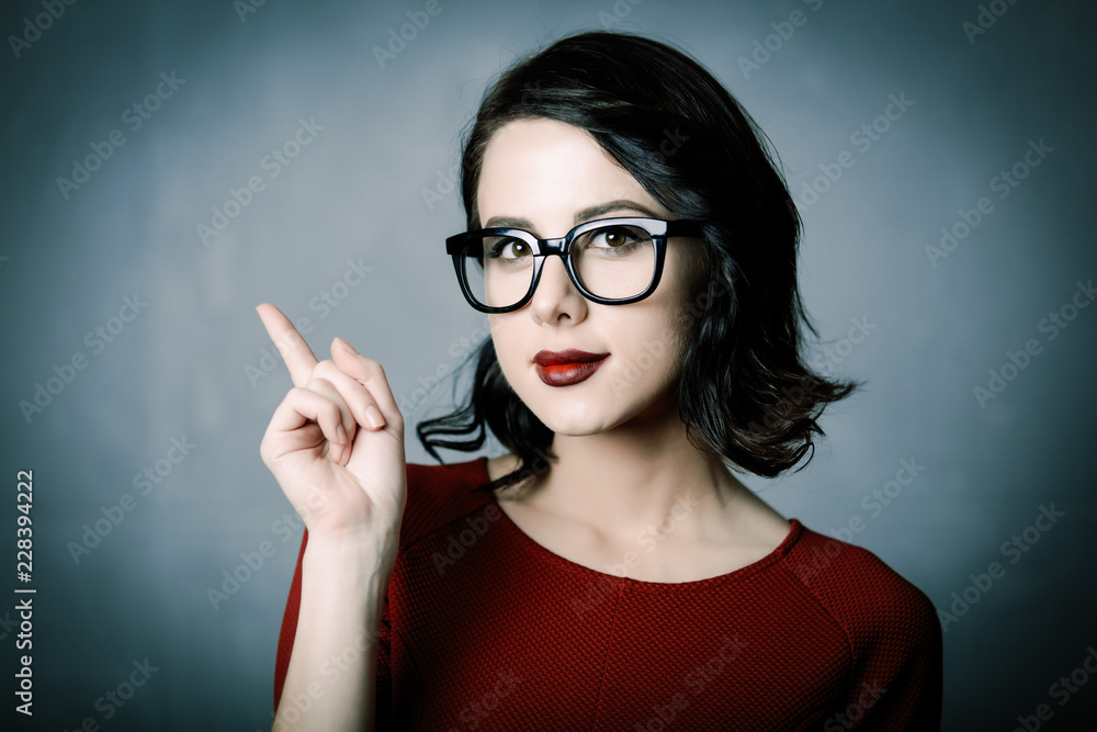 Portrait of a young beautiful lady in glasses over a grey background Portrait of a young beautiful lady in glasses over a grey background