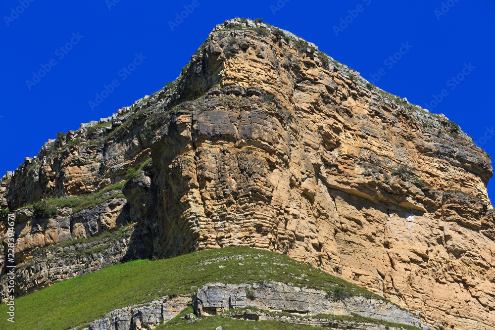 Stone ledge of a rocky ridge against the blue sky.
