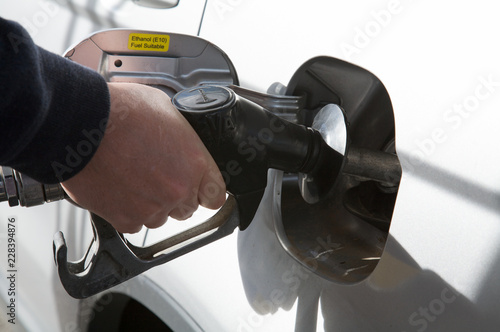 Man filling gas into his car, transportation 