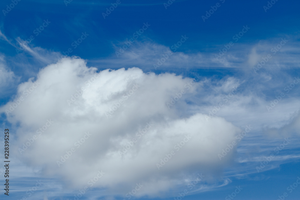 Blue sky with one large, puffy cumulus cloud and some peripheral cirrus clouds. Blue sky with one large, puffy cumulus cloud and some peripheral cirrus clouds.