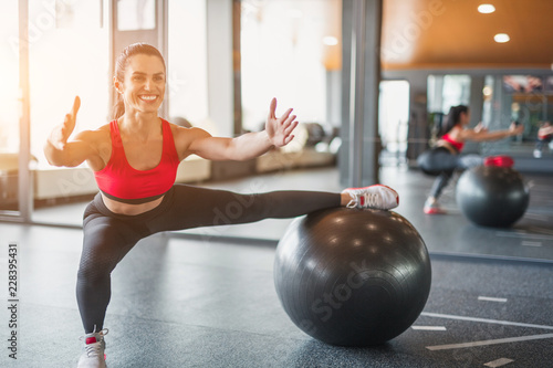 Cheerful woman exercising with Swiss ball