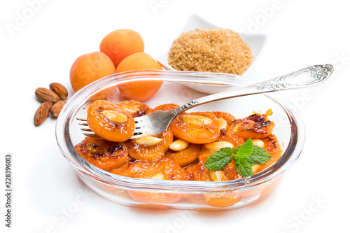Caramelized apricots with almonds isolated on white