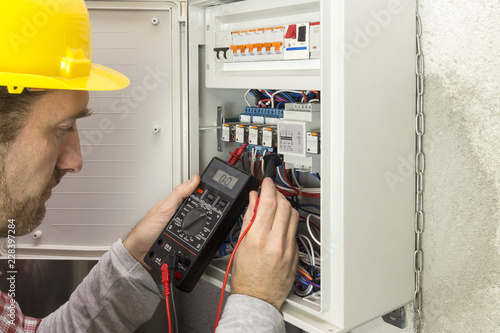 electrician at work measures the electric current