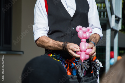wizard creating a pink bear out of a balloon at a children's party