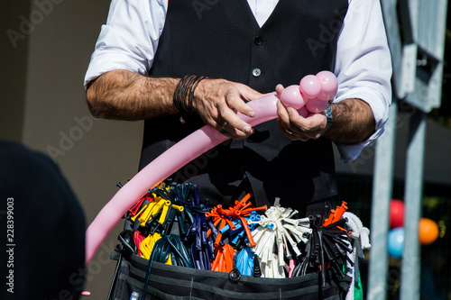 wizard creating a pink bear out of a balloon at a children's party
