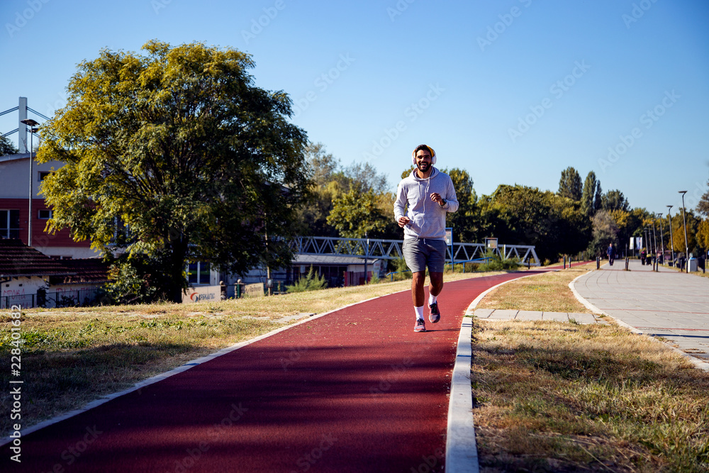 Handsome male runner running at morning