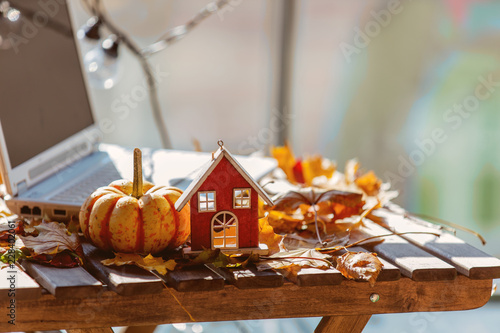 Orange pumpkinm wooden house and leaves