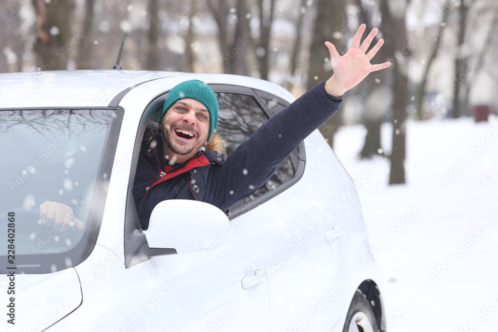 Portrait of car driver with santa hat through car window enjoying the snowy day. On the road winter Portrait of car driver with santa hat through car window enjoying the snowy day. On the road winter