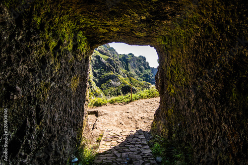 Tunnnel on trekking road on Madeira island. A route between two peaks Pico Ruivo and Pico do Areeiro. Amazing cliff view with tourist on the edge
