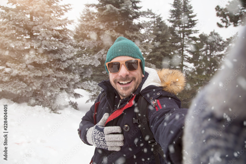 Man with sunglasses taking selfie on snowy day. Man with sunglasses taking selfie on snowy day.