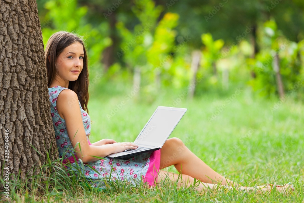 Portrait of a Young Woman Using her Laptop in a Park Portrait of a Young Woman Using her Laptop in a Park