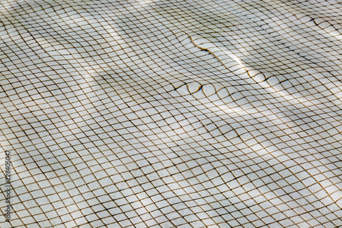 Φωτογραφία Looking down at tiles on the bottom of a pool, distorted through the water