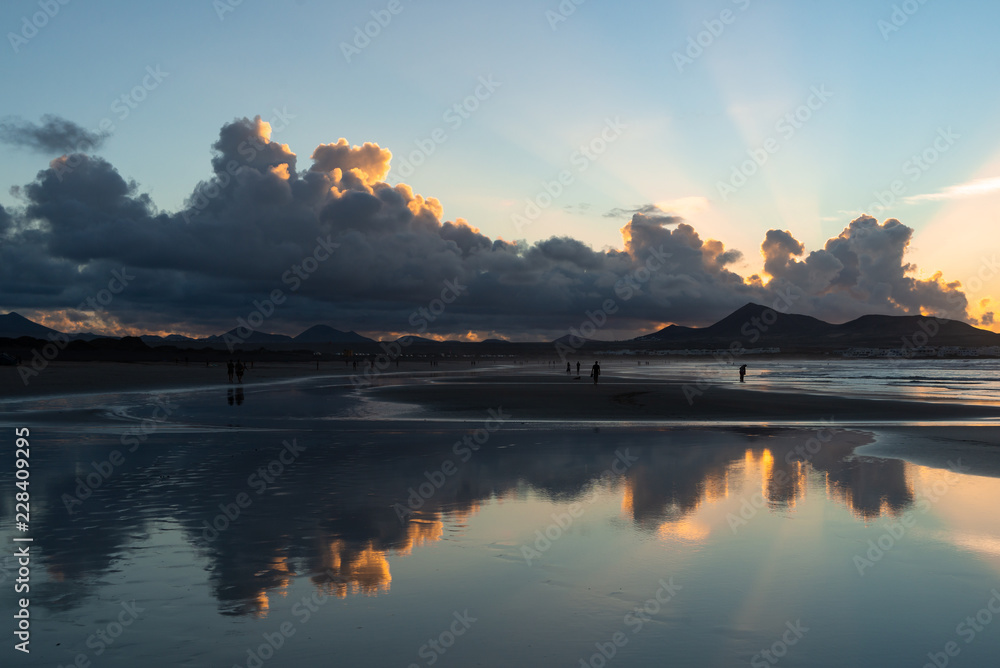 beautiful symmetrical reflection of clouds in a low tide at sunset