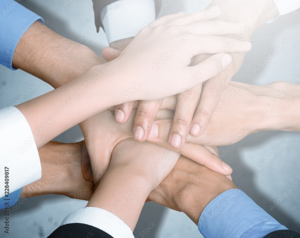 Group of people stacking hands together Group of people stacking hands together