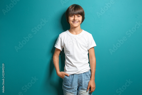 Smiling little boy in t-shirt on color background © Pixel-Shot
