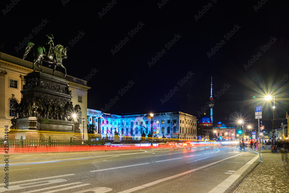Night scenery of street, statue iconic monument, Humbolt university building and background of Berliner Fernsehturm in Berlin, Germany with long exposure and slow shutter speed photography style. 