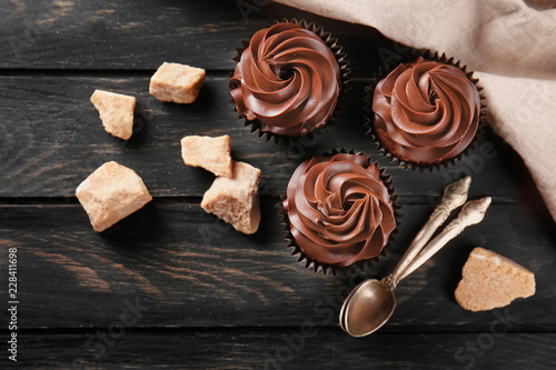 Delicious chocolate cupcakes on wooden table