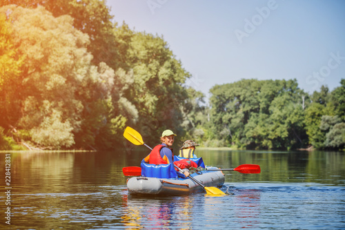 Happy kids kayaking on the river on a sunny day during summer vacation