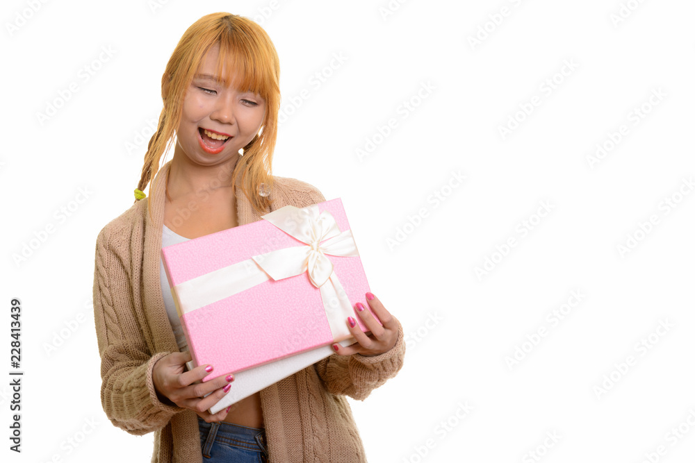 Young happy Asian woman smiling and opening gift box Young happy Asian woman smiling and opening gift box