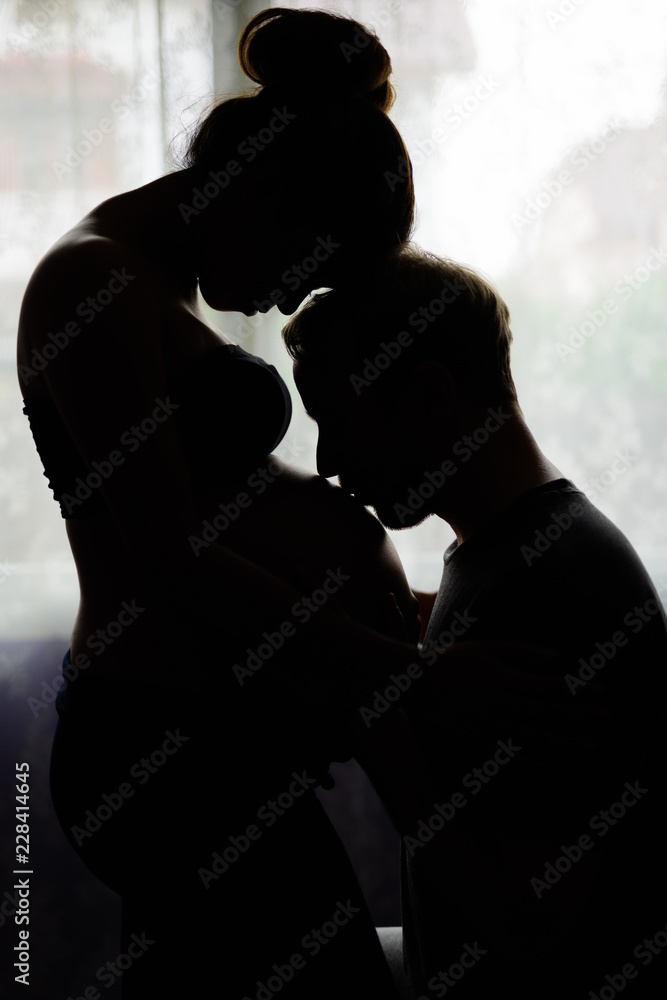 Multi-ethnic couple married and in love in silhouette by the win