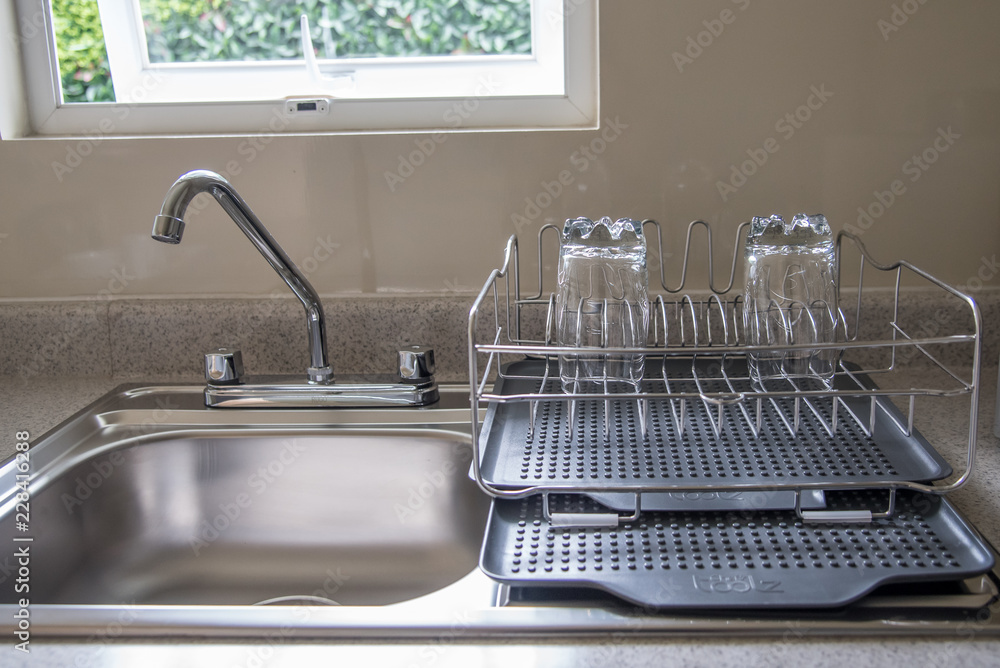 interior de cocina con tarja y griferia plateada, luz interior, escurridor  de platos y vasos interiores foto de Stock | Adobe Stock