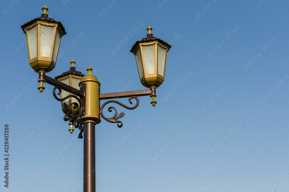 stylized antique street lamp against a blue sky