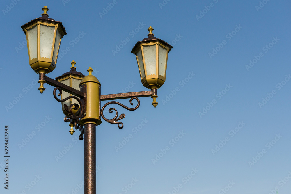 stylized antique street lamp against a blue sky stylized antique street lamp against a blue sky