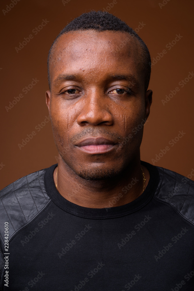 Obraz premium Studio shot of young African man against brown background