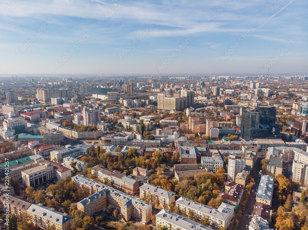 Aerial drone shot of Voronezh downtown with buildings from above, parks, streets with cars in sunny autumn day