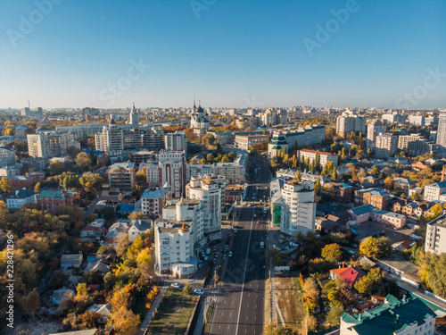 Aerial drone shot of Voronezh downtown with buildings from above, parks, streets with cars in sunny autumn day