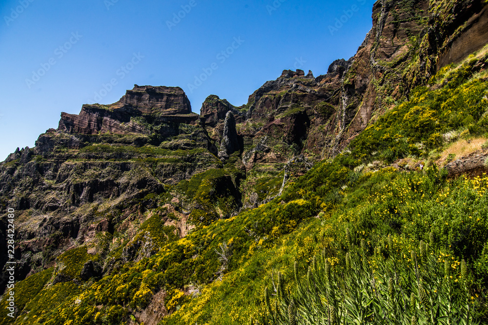 Obraz premium Active lifestyle. Hiking on the beautiful but dangerous hard trekking trail leading from Pico Arieiro peak to the highest mountain of Madeira island, Pico Ruivo