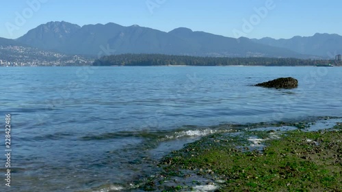 4K: Beach waves of Burrard Inlet and Mountains near Vancouver. photo